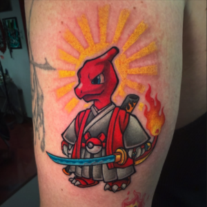 Cartoon red dragon in gray samurai armor, holding a blue curved sword, with a yellow sunburst behind it on the upper arm area.